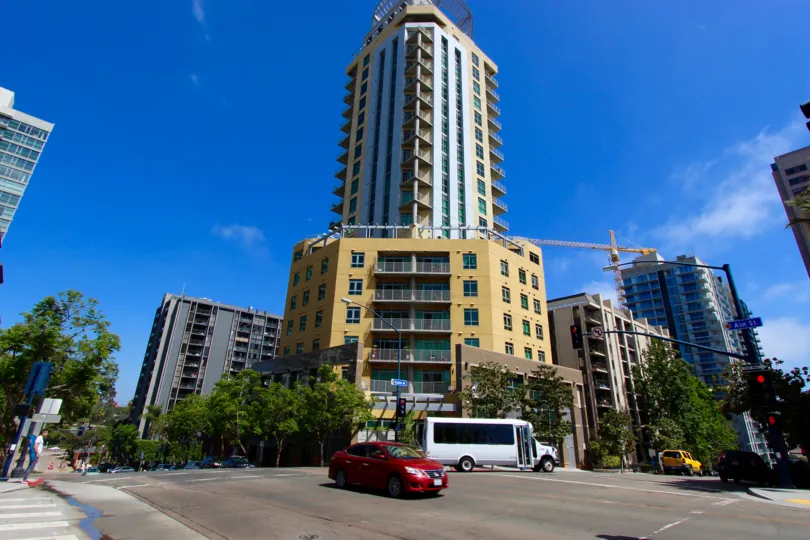 THE BUILIDING IN THE CORTEZ BLU WITH ROAD SIDE TRAFFIC SIGNALS, CARS, VAN.