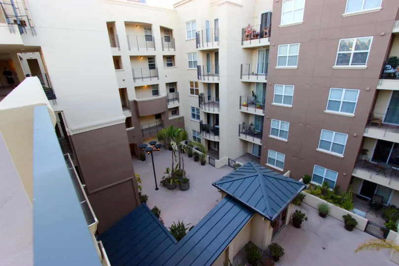 A sunny day in the area of Crown Bay, outside, ariel view, courtyard, highrise, potted plants, lights, balconies