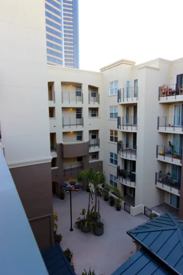 View of the courtyard of the Crown Bay Condos Downtown San Diego California with lighted lampost and potted palm trees in middle