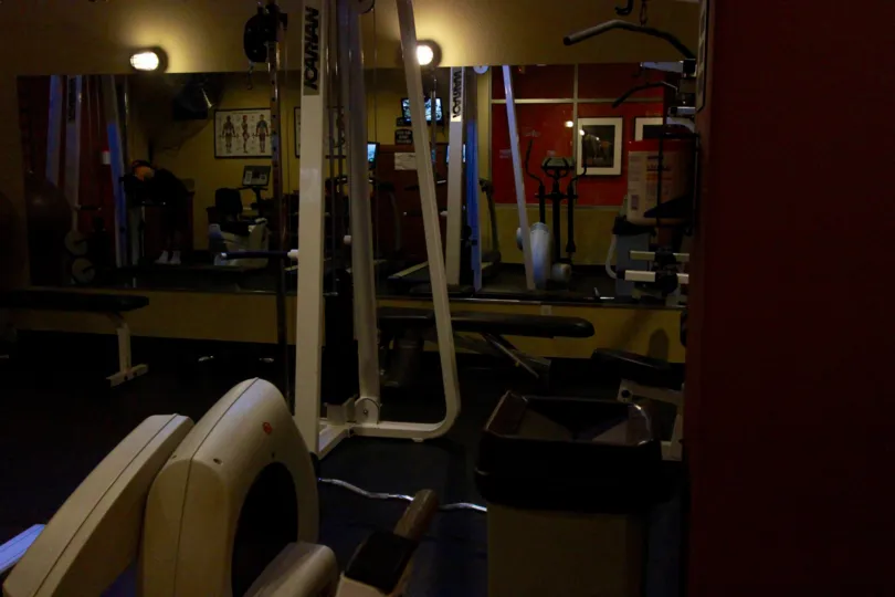 Dimmly lit picture of Work out room of Crown Bay. Mirror reflecting back of room.