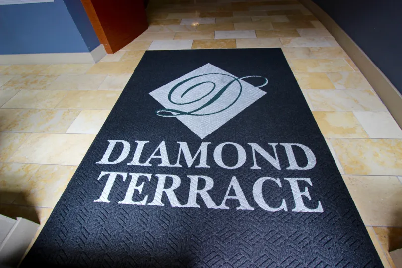 Large black mat with gray writing and shapes inside Diamond Terrace at Downtown San Diego