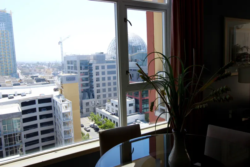 Living room with glass table and view of the city at Diamond Terrace in Downtown San Diego CA