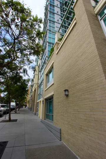 Downtown San Diego California street view with retail space and/or apartments on a tree-lined street with parking