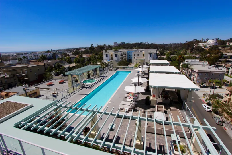 A view of the whole complex of Discovery Apartment with a pool and Downtown San Diego in the background