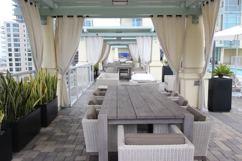 A view of a dining table in a cabanna on the deck of the outdoor pool at the Discovery complex on a sunny day.