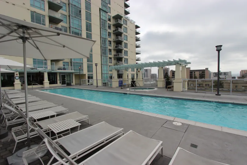 A long, thin pool sits under a dark cloudy sky at Discovery condos