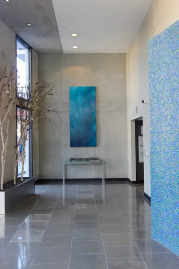 A blue and white tiled art piece in a hallway at DOMA condos