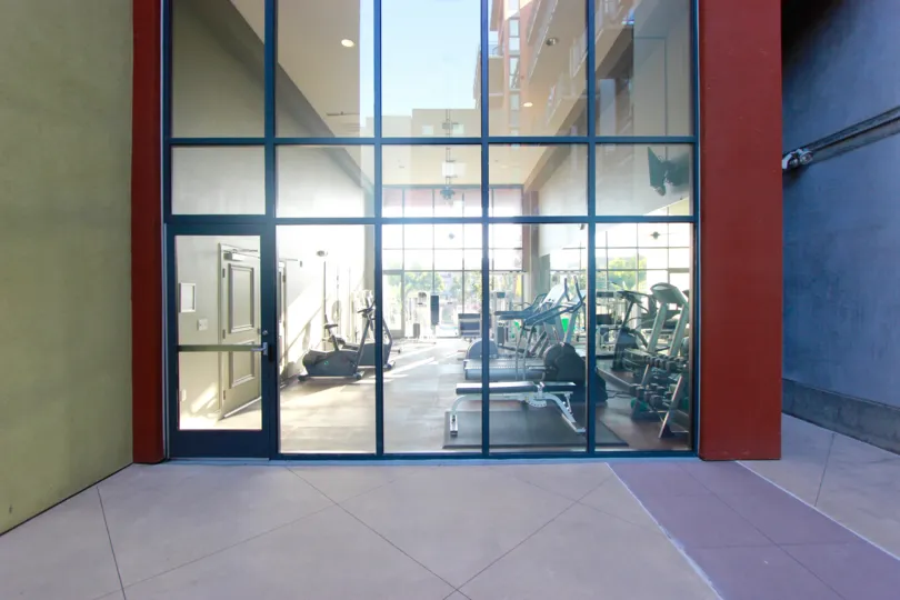 Glass wall & doorway leading to a fitness center at DOMA in Downtown San Diego CA