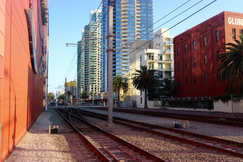 A shady railroad and buildings in downtown San Diego