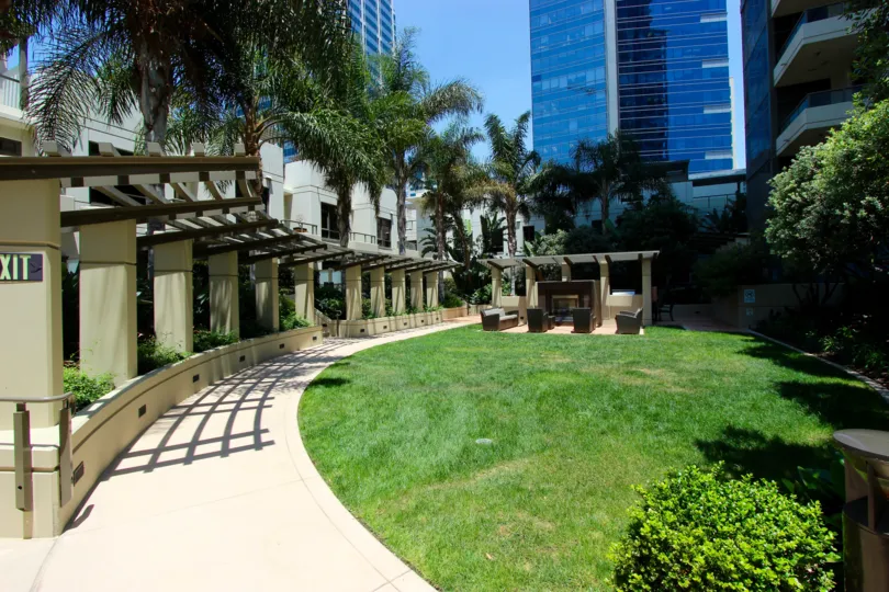 Long walkway along a green field with trees & flowers at Electra in downtown San Diego