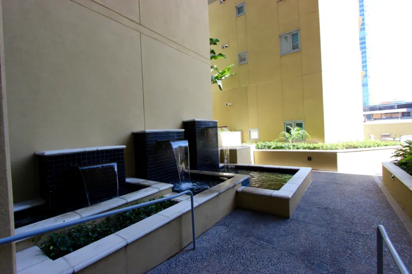 A sunny and bright day at The Element with an exterior view of the therapeutic and refreshing waterfall features and the lush greenery and calm surroundings