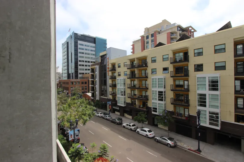 A sunny day outside an apartments with many cars parked outside in Downtown San Diego