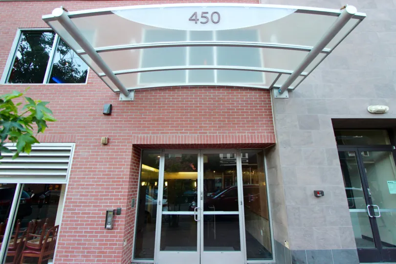 A curved glass awning sits above a door at Gaslamp City Square