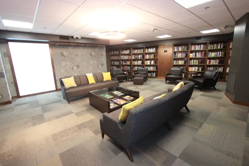 Book shelves line a wall in a community room at Harbor Club