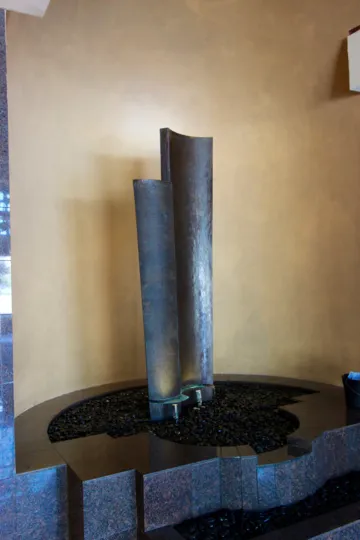 Horbor Club's indoor fountain installment with shiny black rocks.