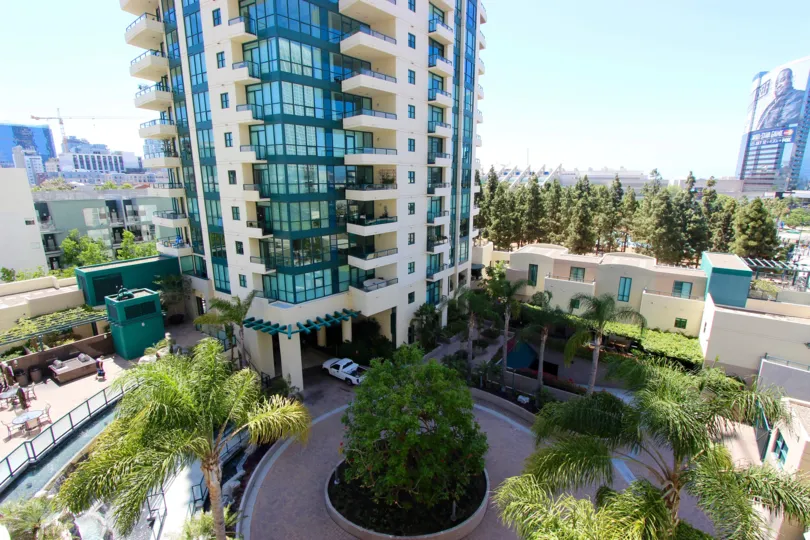 In the Horizons community a tall building is surrounded by trees.
