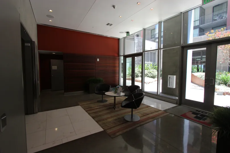 This the lobby of the hotel which has the beautiful glass doors and chairs and also the plants in Icon neighborhood of Downtown San Diego