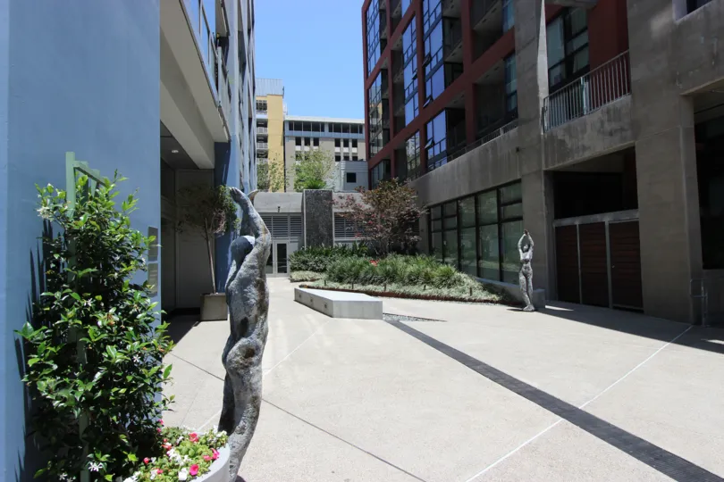 A sunny day in the Icon with some huge buildings and a sculpture.