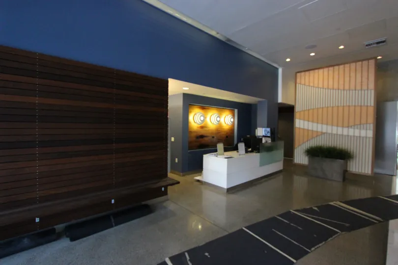 A sunny day in the area of Icon, inside, lobby, bench, lights, desk, plants