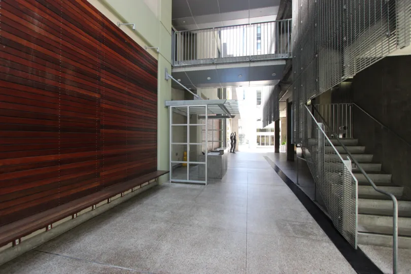 A wood paneled centerpiece wall sits across from a stairwell at Icon condos