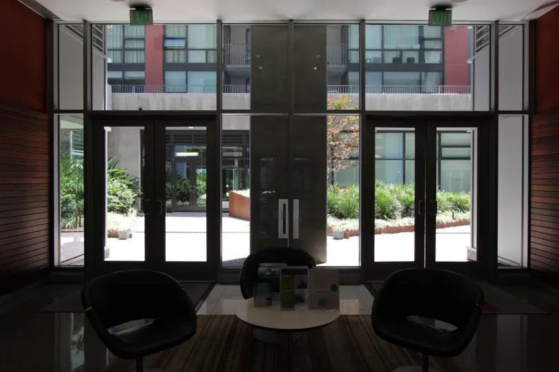 Three chairs sit in the middle of a lobby at the Icon condos