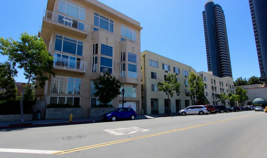 Fron. viewt of Island Lofts Condominium Downtown San Diego California with trees and parked cars