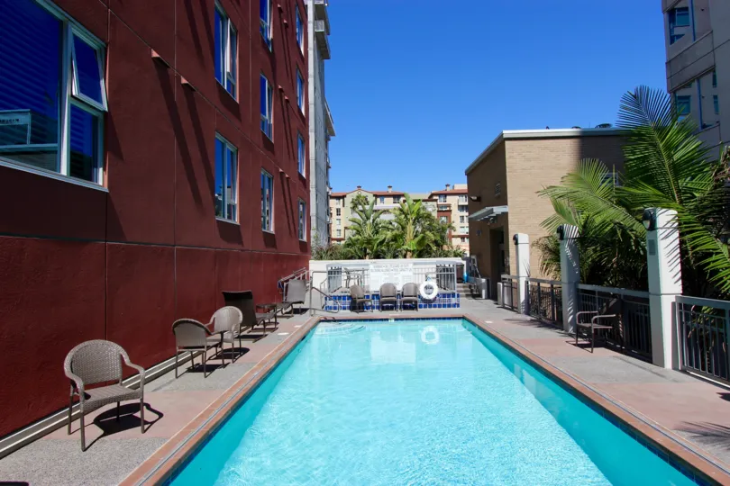 A small pool sits next to a red building at La Vita condos.