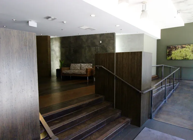 A sunny day in the area of M2i, inside, lobby, stairs, couch, painting, lights