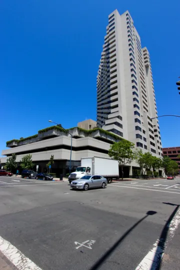 Traffic drives past Meridian condos on a sunny day