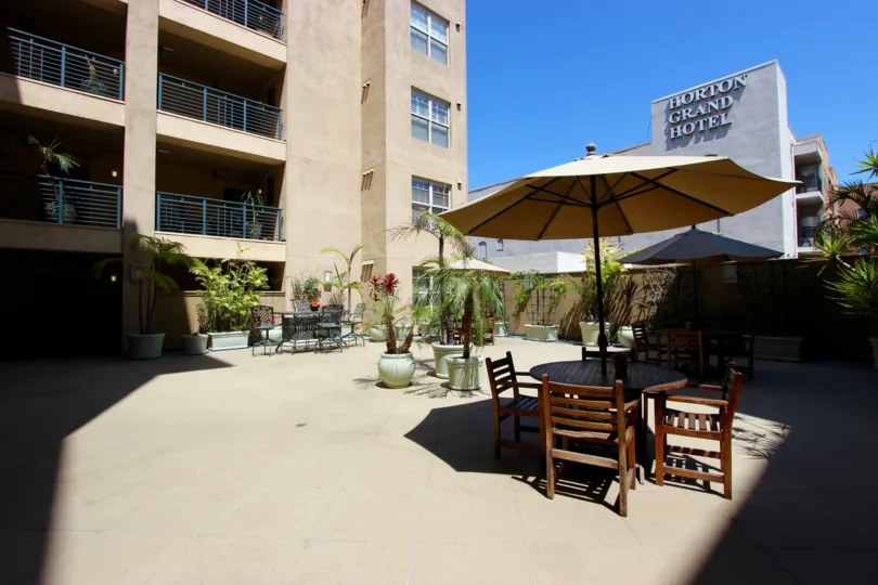 THE HORTON GRAND HOTEL IN THE PACIFIC TERRACE WITH TABLES PLANTS, TREES.