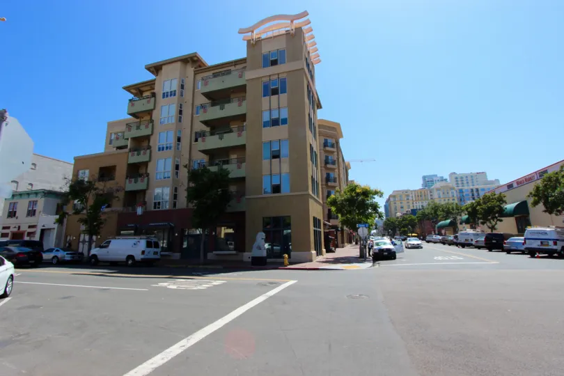 A sunny and cheerful day at the Pacific Terrace with a panoramic view of the classy and contemporary building and the tree-streets with the shops and parked cars