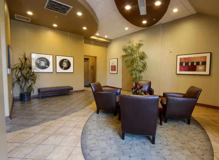 A living room in Pacific Terrace with plants and chairs