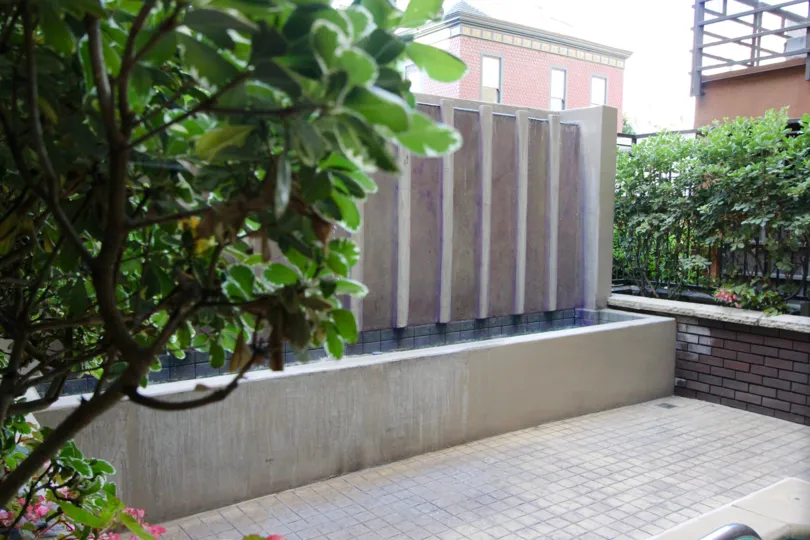 A view of the water feature on a terrace with a brick wall at Park Blvd East.