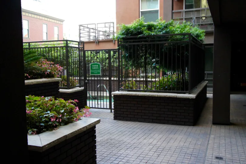 A sunny day in the area of Park Blvd East, outside, fennce, gated entrance, flowers, trees, brick