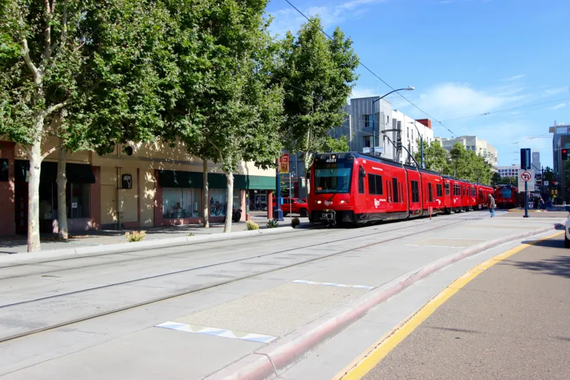A bright red train of Park Blvd West in Downtown San Diego, CA