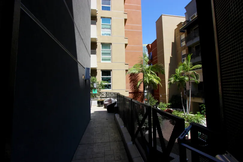 The sun is shining down between buildings in Park Blvd West.