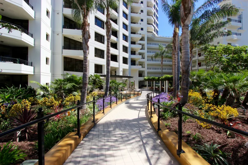Brick walkway lined with colorful flowers & plants in Park Place in Downtown San Diego CA