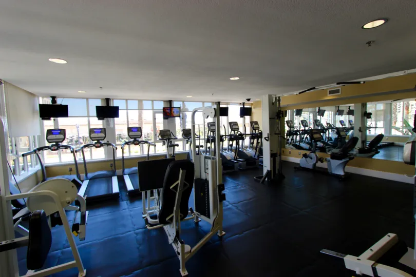 Black tiled floor with exercise equipment sitting inside Park Place in Downtown San Diego CA