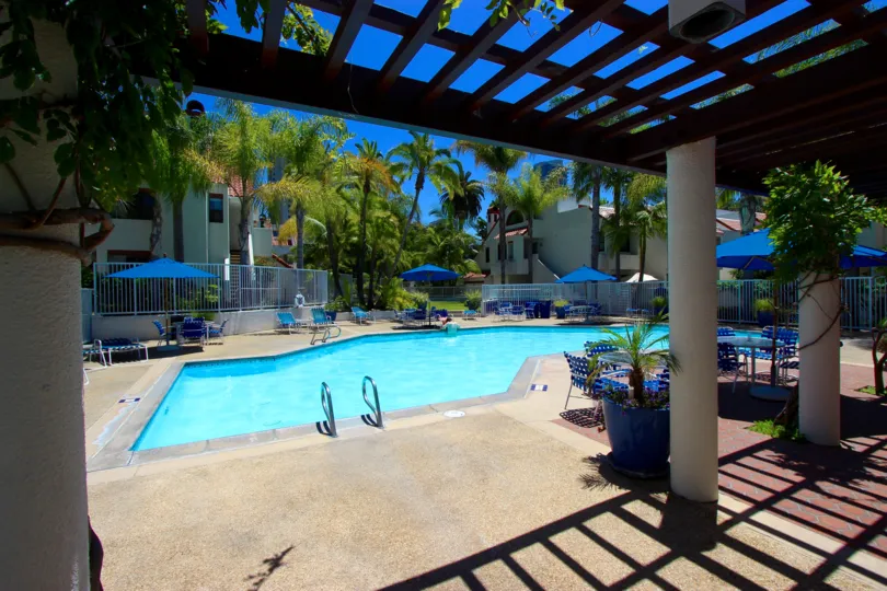 A community pool with chairs and a patio in the Park row neighborhood of San Diego.
