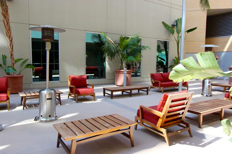 Patio furniture outside of glass windows with a fire lamp at Park Terrace in Downtown San Diego CA