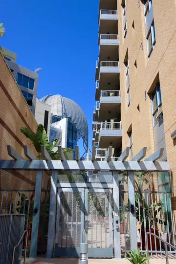 A SUNNY DAY IN THE PARK TERRACE WITH APARTMENT BUILDING AND PLANTS