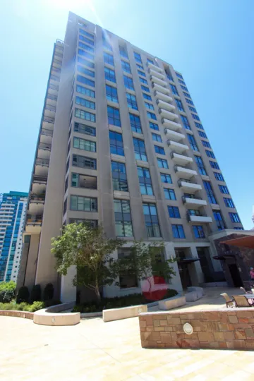 A multi-story white building with windows that reflect the sky in Renaissance neighborhood
