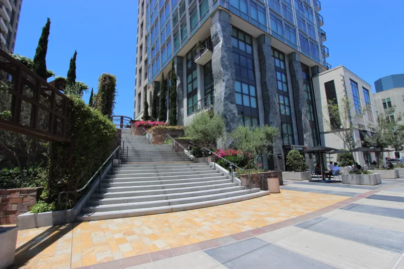 A sunny day in the area of Renaissance, stairway, railing, trees, high rise condos, outside, sidewalk