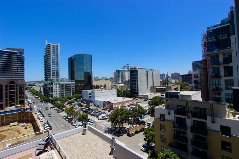 A sunny day in the area of Sapphire Tower, outside, street, vehicles, rooftop, city