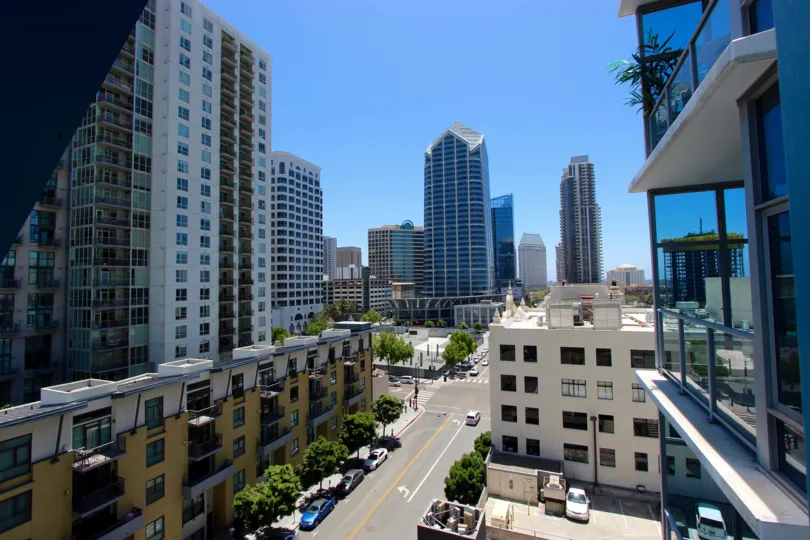 Roadway between tall yellow & white buildings at Sapphire Tower inside Downtown San Diego CA