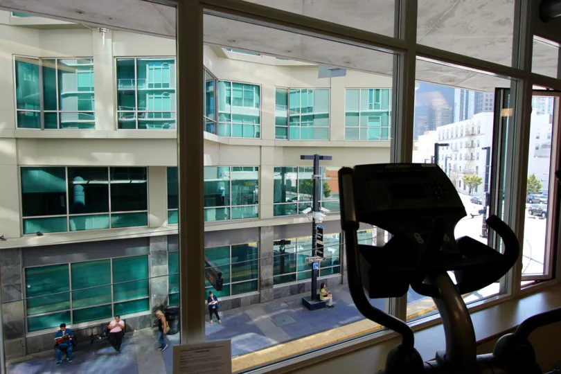 A sunny day in the area of Smart Corner, workout room, eliptical machine, people, outside, windows