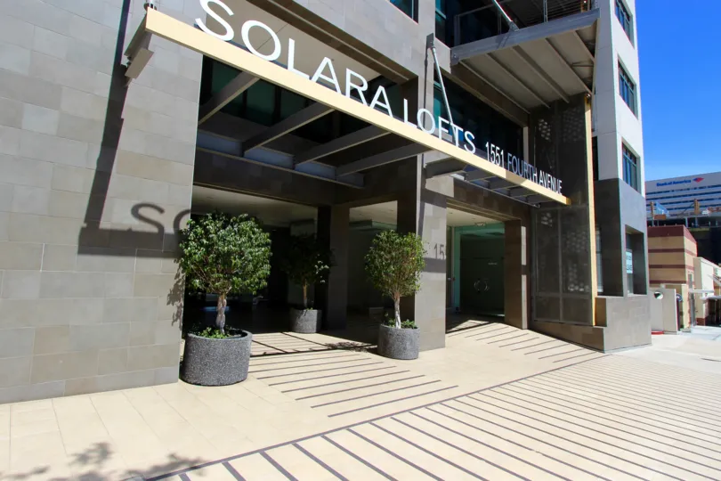 A sunny day in the area of Solara Lofts, outside, entrance, potted plants, sidewalk, highrise