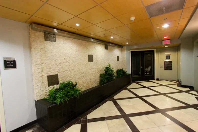 Stone walled and brown and white tilled lobby with yellow ceiling.