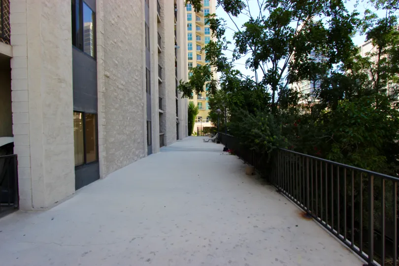A long, shaded walkway sits next to a gate at the Symphony Terrace condos