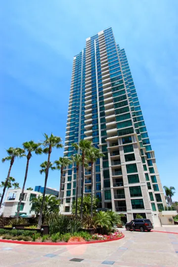 Trees in front of the tower of The Grande in downtown San Diego, CA